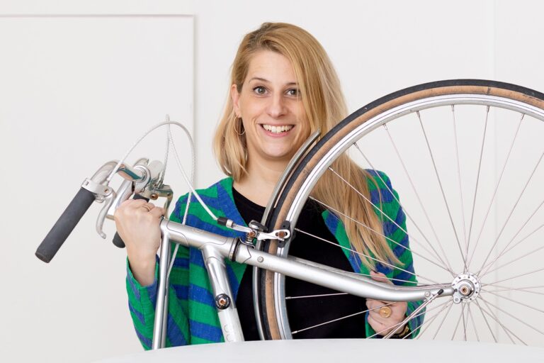 Franziska Falco stet an einem Tisch und präsentiert Ihr Fahrrad.